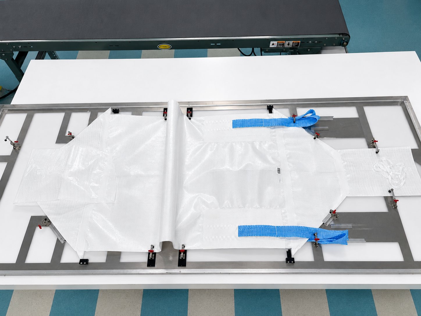 A completed Fusion&reg; bag on its carrier plate at the end of the sealing line, lift loops attached
